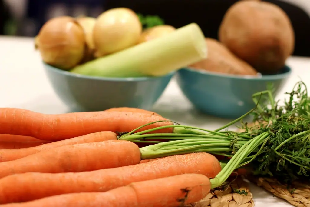 Carottes, oignons et pommes de terre sur une table de cuisine